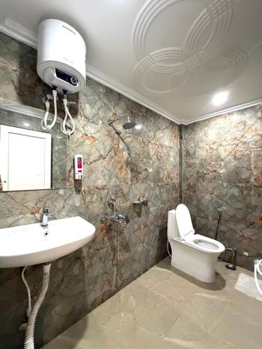 a bathroom with a sink and a toilet at Hotel The Pushpraj in Varanasi