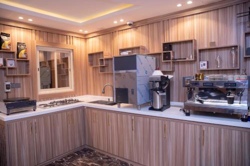 沙鲁拉بن سنكر لشقق المخدومة的一个宽敞的厨房，墙壁是木质的，配有大型电器。