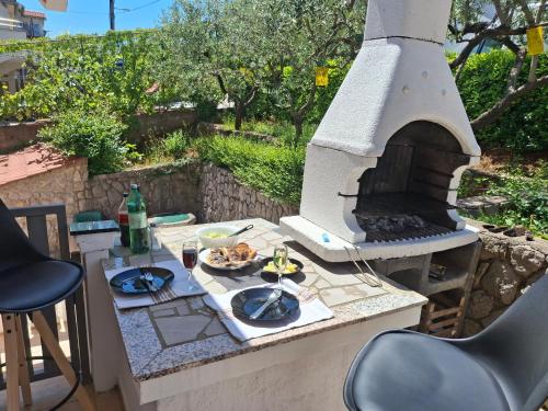 een tafel met een pizza-oven op een patio bij Blue Ivy App Salatić Besplatno korištenje električnih bicikala in Vrh
