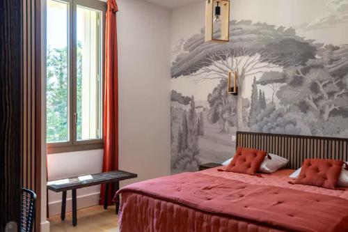 une chambre avec un lit rouge avec un tableau sur le mur dans l'établissement Bastide des Oliviers, Maison Provençale, à Boulbon