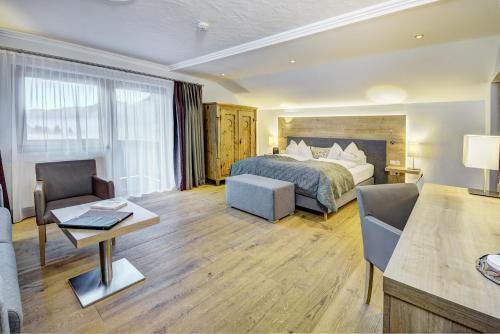 a hotel room with a bed and a desk at Hotel Unterhof in Filzmoos