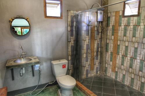 a bathroom with a shower and a toilet and a sink at Above The Sea Maesariang in Mae Sariang