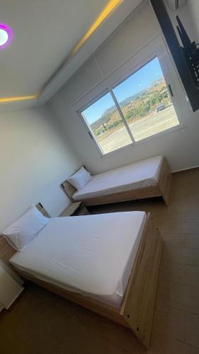 丹吉尔Mirasol achakar的一间卧室，配有两张床和一扇窗户