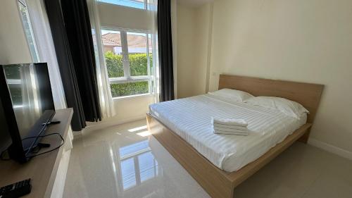 een slaapkamer met een bed met witte lakens en een raam bij Holiday home in Ban Na Khua
