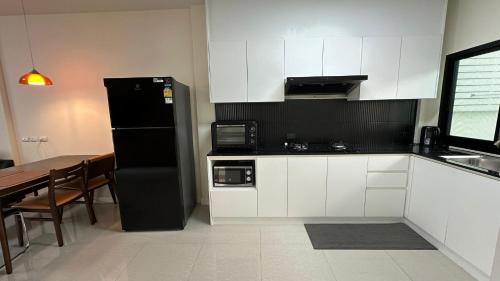 een keuken met een zwarte koelkast en een tafel bij Holiday home in Ban Na Khua