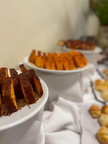 twee borden met eten op een tafel met andere borden met eten bij Rovi Plaza Hotel in Serra Negra