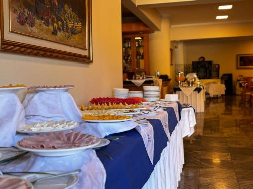 een rij tafels met borden met voedsel erop bij Rovi Plaza Hotel in Serra Negra