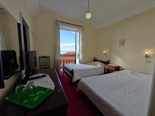 een hotelkamer met twee bedden en een televisie bij Mirasol Guesthouse in Funchal