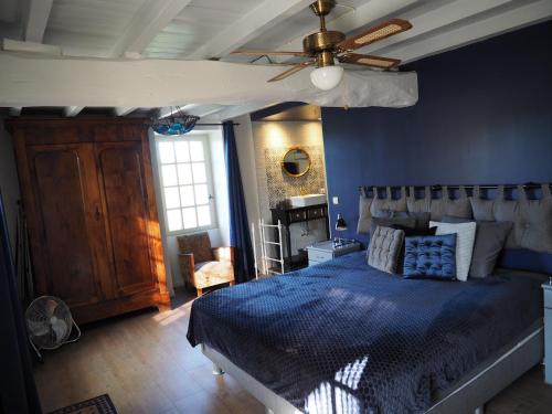 une chambre avec un lit et un ventilateur de plafond dans l'établissement Domaine du Cammazet, à Lapenne