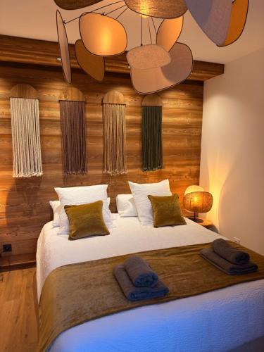 a bedroom with a large bed with two towels on it at SixT Lodge in Saint-Jean-de-Sixt