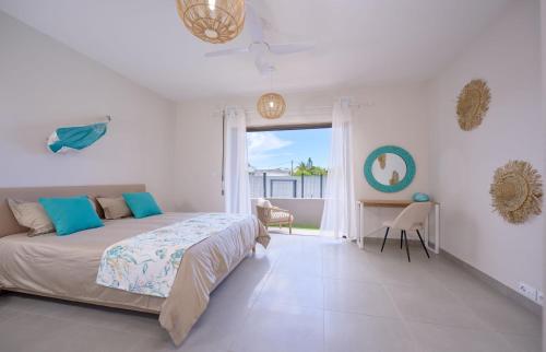 een slaapkamer met een bed, een tafel en een raam bij Résidence ORYAM B21 in Pointe aux Biches