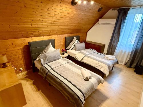 zwei Betten in einem Zimmer mit Holzwänden in der Unterkunft Haus noe in Kehl am Rhein