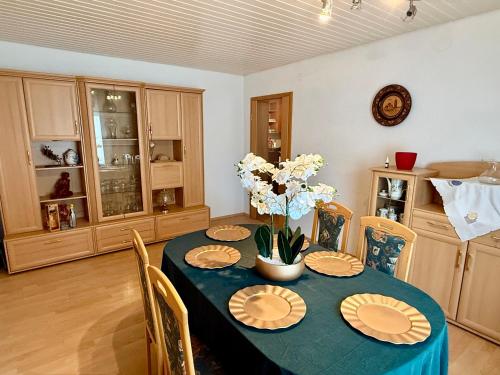 a dining room table with plates and flowers on it at Haus noe in Kehl am Rhein