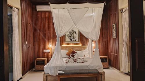 a bedroom with a bed with a canopy at Asri Sari Ubud Resort in Ubud