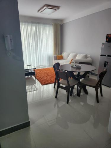 een woonkamer met een tafel, stoelen en een bank bij Haven Place 254 in Nairobi