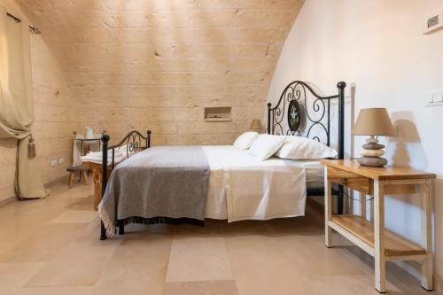 una camera da letto con un letto e un tavolo di legno di Antico Casolare P. P. a Otranto