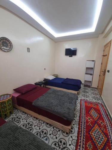 a bedroom with two beds and a tv on the ceiling at Dar Kawtar in Marrakesh