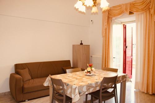 ein Wohnzimmer mit einem Tisch und einem Sofa in der Unterkunft Villa Rosanna's Haven-Relax a pochi minuti da Monopoli in Antonelli