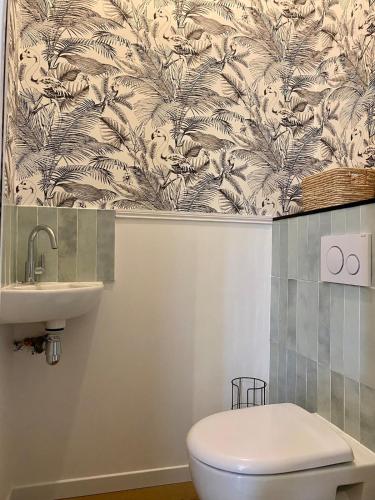 a bathroom with a toilet and a sink at La Parenthèse Champenoise in Épernay