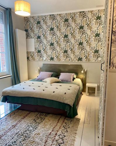 een slaapkamer met een bed met een bloemenbehang bij La Parenthèse Champenoise in Épernay