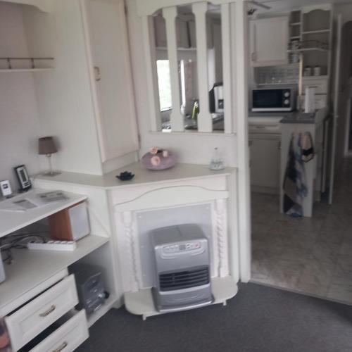 a kitchen with a white counter with a computer in it at Stacaravan Camping It Wiid Earnewoude in Earnewâld