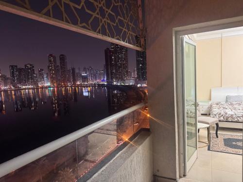 a view of a city skyline at night from a balcony at Sryia 1 in Sharjah