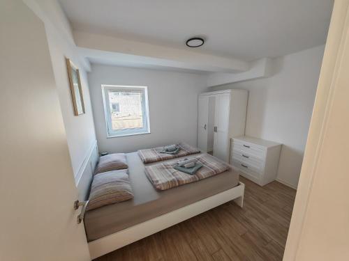 a small bedroom with a bed and a window at Apartments Pronavtik in Piran