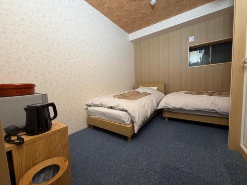 a hotel room with two beds and a tv at 湯沢粉雪の宿 in Yuzawa