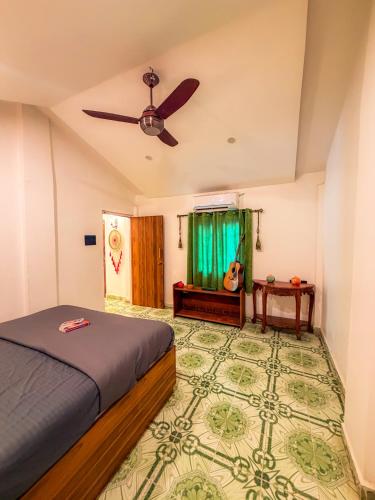 ein Schlafzimmer mit Bett und Deckenventilator in der Unterkunft Traverse Homes Palolem in Canacona