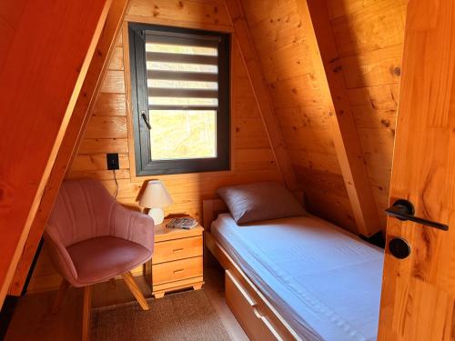 een kleine kamer met een bed en een stoel in een hut bij Vikendica Vista in Vrdnik