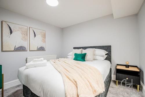 a white bedroom with a large bed with a blanket on it at Guest Stays - Bridge Street Studio 2 in Evesham
