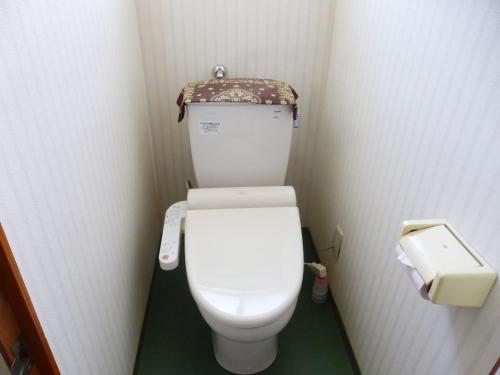 a small bathroom with a toilet in a stall at Kagura House in Yuzawa