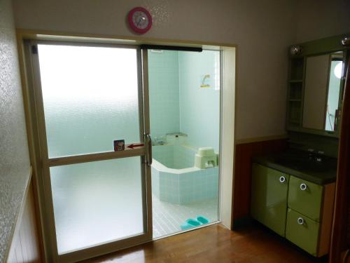 a bathroom with a glass shower with a tub at Kagura House in Yuzawa