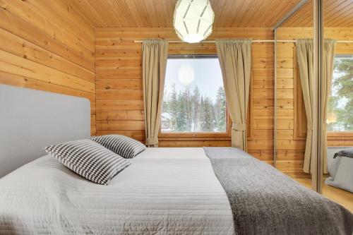 a bedroom with a large bed and a window at Pyhäkoti A - 30 Meters From the Slopes - Valkea Homes in Pyhätunturi