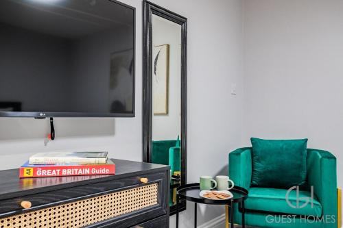 a living room with a green chair and a mirror at Guest Stays - Bridge Street Studio 2 in Evesham