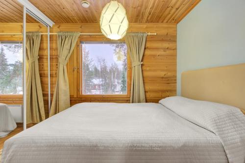 a bedroom with a bed and a large window at Pyhäkoti B - 30 Meters From the Slopes in Pyhätunturi