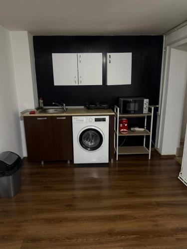 a kitchen with a washing machine and a microwave at Central in inima orasului in Ploieşti