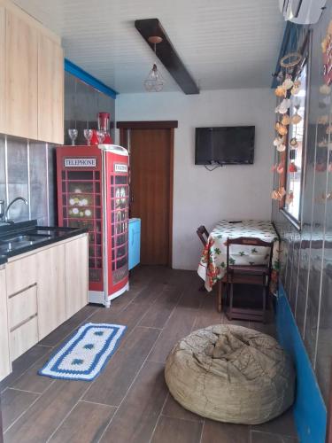 a kitchen with an old red refrigerator and a table at Recanto da onça in Matinhos