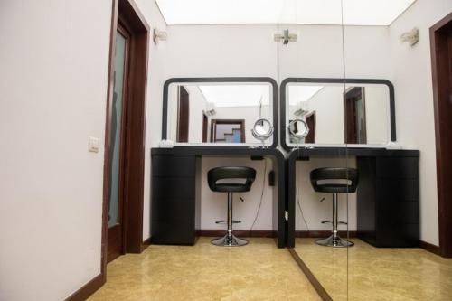 een kleedkamer met 2 spiegels en 2 krukken bij Villa with Pool Bragadiru in Bragadiru