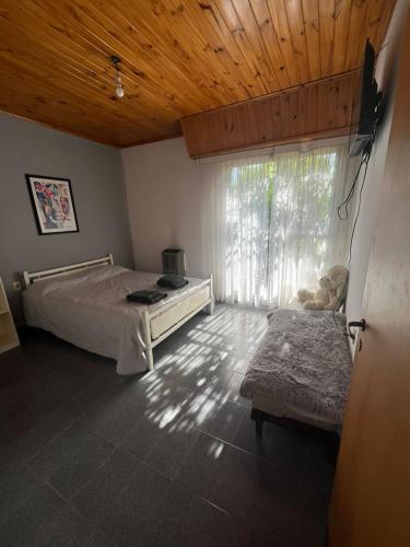 a bedroom with a bed and a large window at Bochita in Tornquist