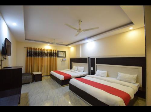 a hotel room with two beds and a tv at HOTEL THE TARANANT in Katra