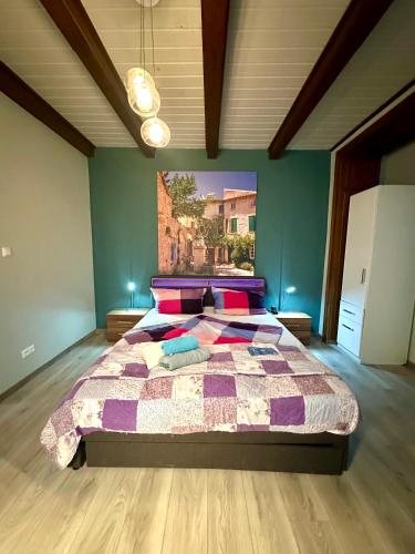 a bedroom with a large bed with purple and pink pillows at Optimus Mechernich in Mechernich