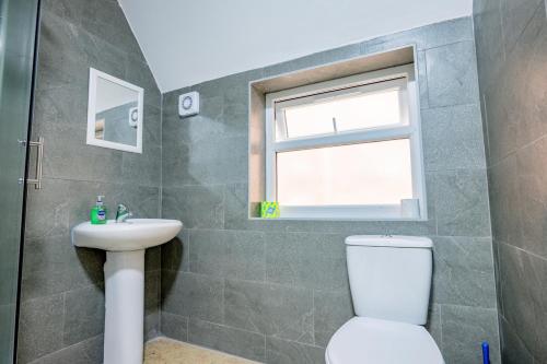 ein Badezimmer mit Toilette und Waschbecken und einem Fenster in der Unterkunft Bromyard Flat 3 - Relax & Unwind in Worcester