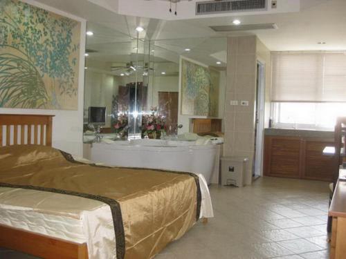a bedroom with a tub and a large bathroom at DAO Studio Apartments in Patong Beach