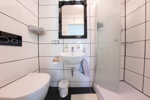 a bathroom with a sink and a toilet and a mirror at Pension Gino in Nürtingen