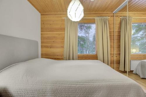 a bedroom with a white bed and a window at Pyhäkoti C - 30 Metres From the Slopes - Valkea Homes in Pyhätunturi