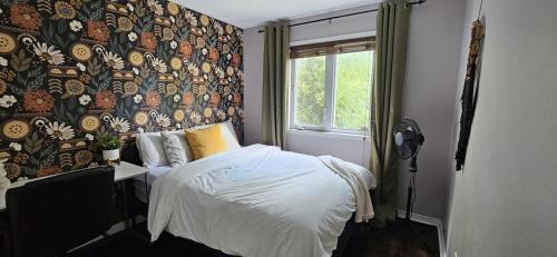a bedroom with a bed and a wall with a window at Boho Retreat 3BD Condo Close to Ottawa in Gatineau