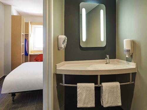 ein Badezimmer mit Waschbecken und Bett in der Unterkunft Ibis Culiacan in Culiacán Rosales