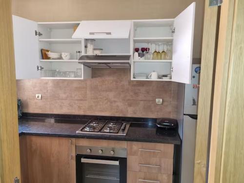 a kitchen with white cabinets and a stove top oven at appartement prestige golf city in Marrakech