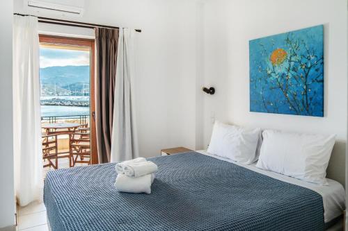 a bedroom with a bed with a view of the ocean at Renas Guesthouse in Sitia